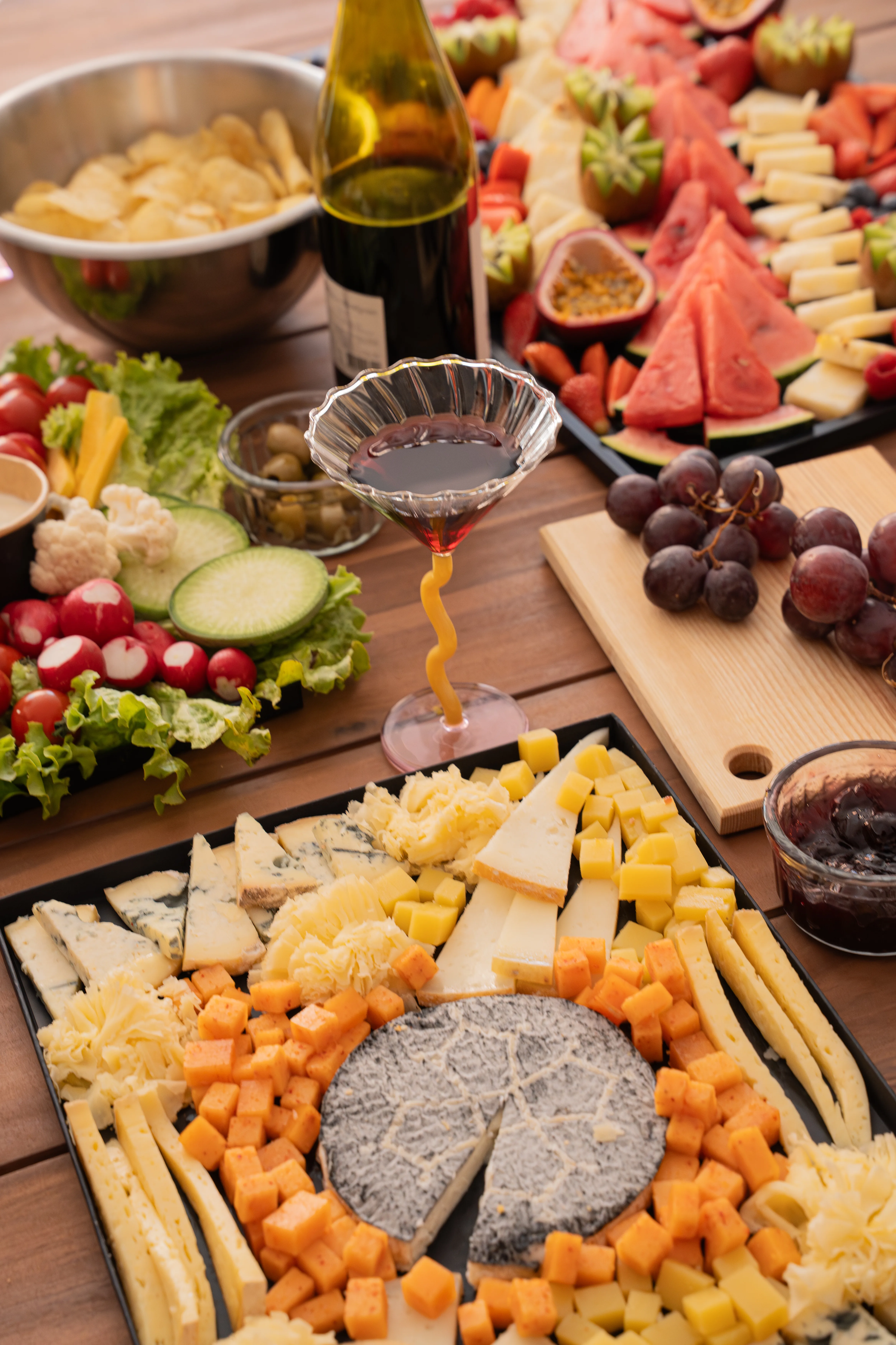 Buffet apéro avec planche de fromages, fruits frais et coupe de vin