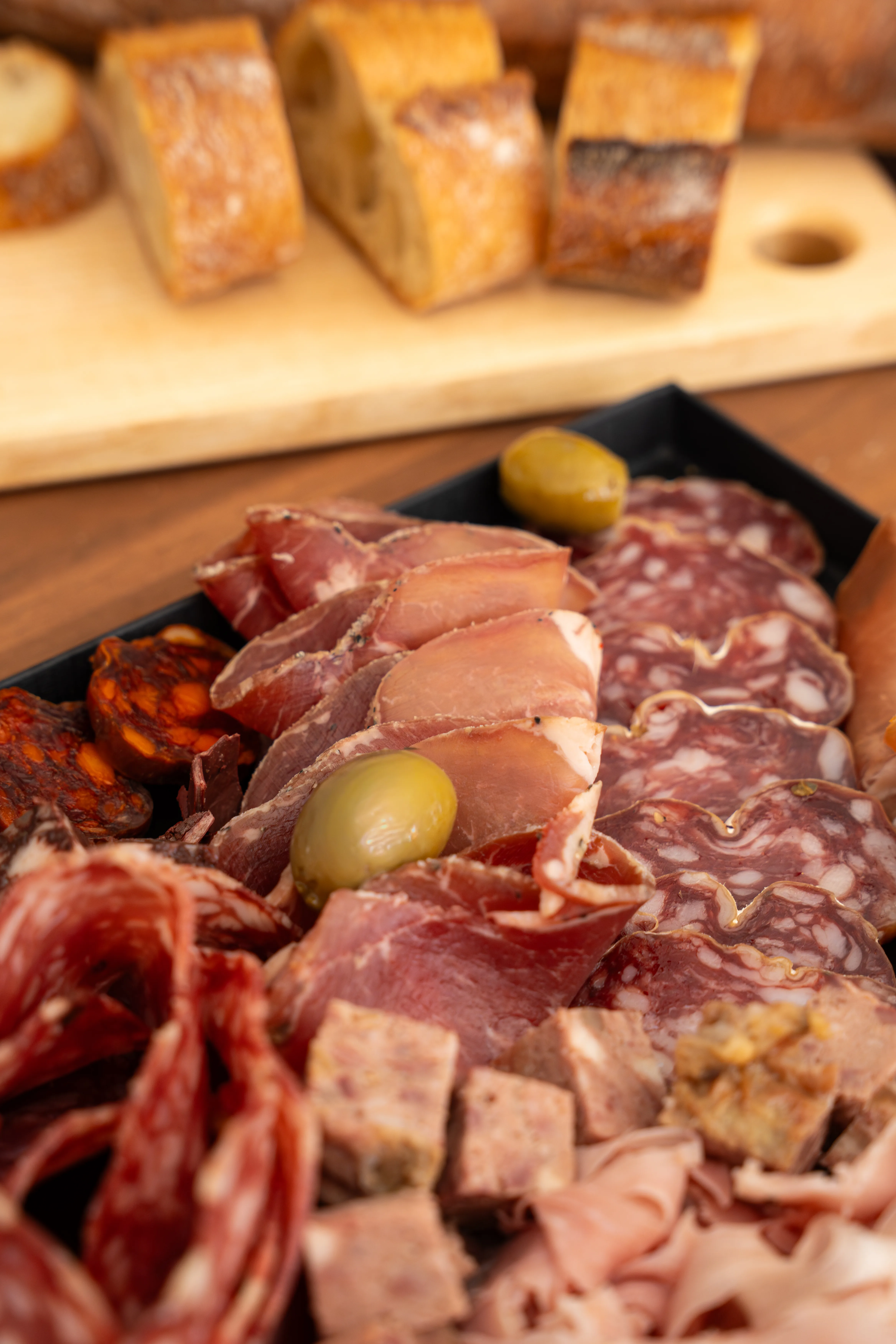 Planche de charcuteries artisanales avec olives et pain